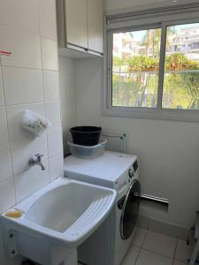 uma casa de banho com uma máquina de lavar roupa e uma janela em 101 - EM FRENTE AO HOSPITAL ALBERT EINSTEIN em São Paulo