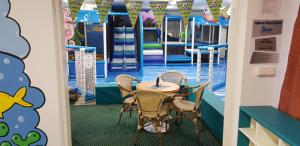 een tafel en stoelen in een speelkamer met een zwembad bij Golf Hotel Austerlitz in Slavkov u Brna