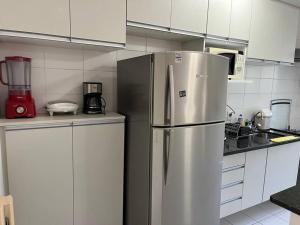 uma cozinha com um frigorífico de aço inoxidável e armários brancos em 101 - EM FRENTE AO HOSPITAL ALBERT EINSTEIN em São Paulo