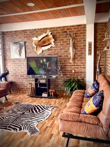 sala de estar con sofá y pared de ladrillo en Casa Africa en Calima