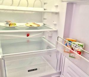 un frigorifero aperto con un piatto di cibo di Nouvel appart cosy, centre Tours a Tours Altre 8 foto