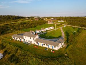 - une vue aérienne sur une grande maison dans une ferme dans l'établissement Cape View Motel & Cottages, à Mavillette
