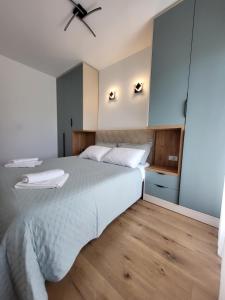 sypialnia z dużym łóżkiem i wentylatorem sufitowym w obiekcie 2B Apartment w mieście Petrovec
