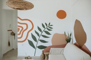 ein Wohnzimmer mit einem Sofa und einer Pflanze an der Wand in der Unterkunft Aloe Comfort House by KHI in Kythnos