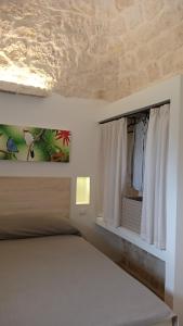 a bedroom with a bed and a window at Trullo Pettirosso Ostuni in Ostuni
