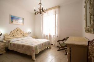 a bedroom with a bed and a desk and a window at Appartamento Il Veliero Vista Darsena in Portoferraio +3 photos