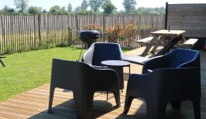 a group of chairs and tables on a deck at Cottage Le Phare in Mont-Dol +42 photos