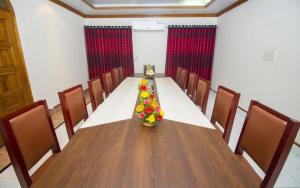 una sala de conferencias con una mesa larga con flores. en Hotel Suite Palace Baridhara, en Dhaka