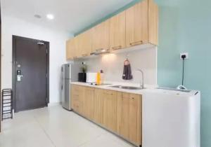 a kitchen with wooden cabinets and a refrigerator at KSL Mall - High Speed WiFi - Bathtub - Netflix - 24-7 Support in Johor Bahru