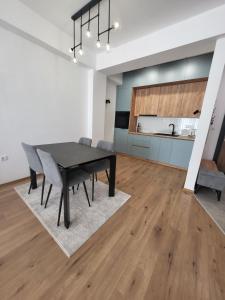 a dining room with a black table and chairs at 2B Apartment in Petrovec
