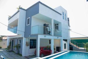 a white house with a pool in front of it at 5 Bedrooms Luxury Vacation Villa in Accra