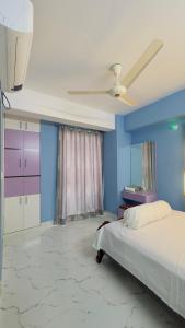 1 dormitorio con cama y pared azul en Baridhara Sweet Home, en Dhaka
