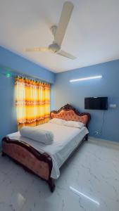 1 dormitorio con 1 cama grande y ventilador de techo en Baridhara Sweet Home, en Dhaka