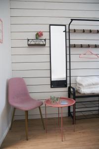 une chaise, une table et un miroir dans la chambre dans l'établissement B&B Korsman Hanko, à Hanko