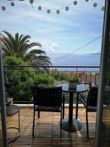 une terrasse avec une table et des chaises et l'océan dans l'établissement APARTMENT IZABELA Opatija, à Opatija