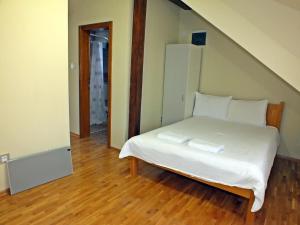 a bedroom with a bed with white sheets and pillows at Nika's House Trosobna kuća sa trpezarijom i kuhinjom,u skopu jos dva apartmana,bazen,terasa i sauna in Palić