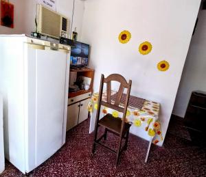 uma cozinha com uma cadeira e um frigorífico branco em Jasy Hospedaje em Paraguarí