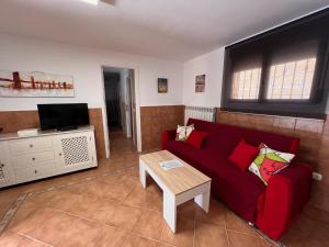 - un salon avec un canapé rouge et une table dans l'établissement La Casita de Yuncos, à Yuncos