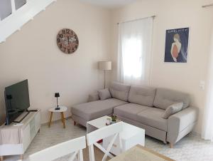 a living room with a couch and a tv at Voula's maisonette in Acharavi