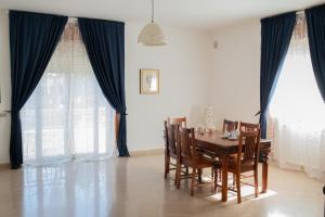 jadalnia z drewnianym stołem i krzesłami w obiekcie Villa Cristina B&b Alezio w mieście Alezio