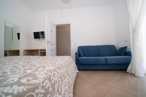 sypialnia z łóżkiem i niebieską kanapą w obiekcie Villa Cristina B&b Alezio w mieście Alezio
