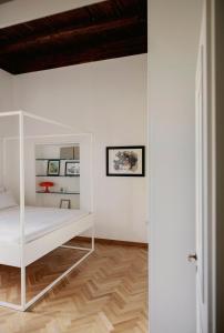 a bedroom with a white bed and a wooden floor at Posillipo 70 Napoli in Naples