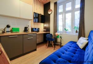 sala de estar con sofá azul y cocina en BaySide Apartments Marina Center en Gdansk