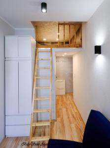 Cama elevada en habitación con escalera en BaySide Apartments Marina Center en Gdansk