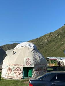 a yurt with a car parked in front of it at Зона отдыха Махат in Kurmenty