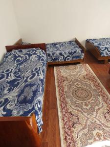 two beds sitting on top of a wooden floor with a rug at Зона отдыха Махат in Kurmenty