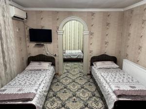 dwa łóżka w pokoju z telewizorem na ścianie w obiekcie BARNO 
