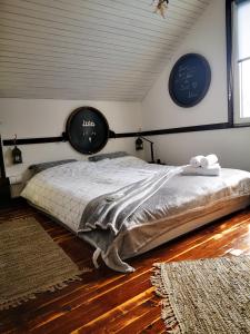 a bedroom with a bed with two clocks on the wall at Solarna Eko Vila - Your Boutique Mountain Escape in Divčibare
