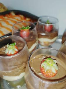 um grupo de sobremesas em copos de vidro com um morango em cima em Mandacaru pousada em Maceió
