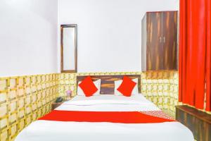 ein Schlafzimmer mit einem großen Bett mit roten Kissen in der Unterkunft Hotel Dolphin in Lucknow