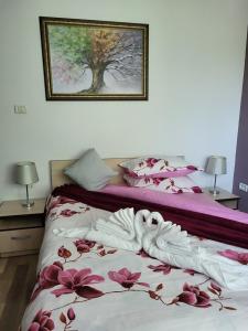 1 dormitorio con 2 camas y un cuadro en la pared en Dumbrava Ursului, en Zărneşti