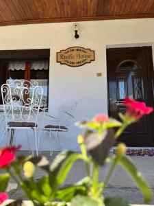Ein Tisch und Stühle vor einem Haus mit einem Schild in der Unterkunft Rustic House in Miléa
