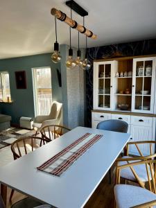 cocina y comedor con mesa blanca y sillas en Go out stay wild en Norsjö