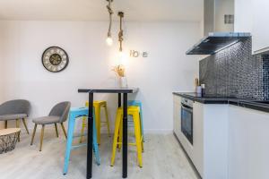 a kitchen with yellow and black tables and chairs at BaruHaus Estrella Mansilla in Mansilla de las Mulas