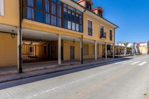 eine leere Straße neben einem gelben Gebäude in der Unterkunft BaruHaus Estrella Mansilla in Mansilla de las Mulas