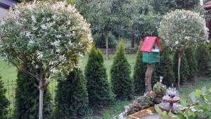 a garden with a bird house on a tree at Apartman Bubamara in Arilje