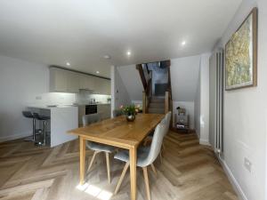 a kitchen and dining room with a wooden table and chairs at Daisy Cottage in Keswick