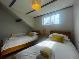 two twin beds in a room with a window at Daisy Cottage in Keswick