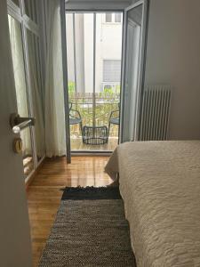 a bedroom with a bed and a view of a balcony at Cozy Athena Apartment in Athens