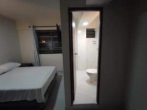 a bedroom with a bed and a bathroom with a toilet at Hostal Independencia in Santa Cruz de la Sierra