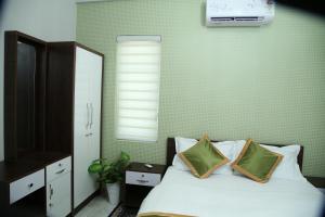 a bedroom with a bed with two pillows and a window at 88 homes kochi in Ernakulam