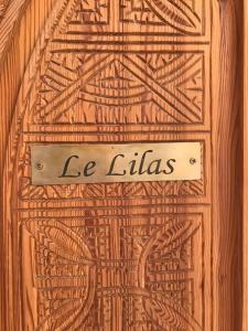 une porte en bois avec un panneau indiquant l'ellias dans l'établissement Flottement Des Songes, à Marrakech