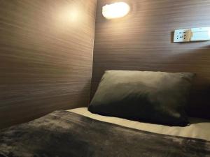 a bedroom with a bed with a brown head board at SUSU khaosan hostel in Bangkok