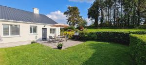 un patio trasero con una mesa de picnic en el césped en Farnaught Farmhouse Apartment, Lough Rynn, Mohill en Farnaght