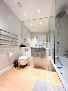 La salle de bains est pourvue de toilettes, d'une douche et d'une baignoire. dans l'établissement Upper Riverside O2 2Bedroom Flat 05, à Londres