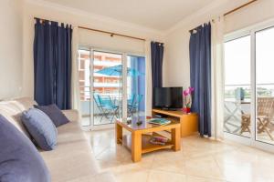 un soggiorno con un divano e un tavolo di Casa Azul, Fast WI-FI, Airco, Pool & BBQ near The Beach Praia da Rocha a Portimão